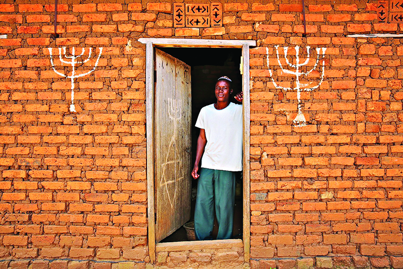 Joseph Mwanika in the doorway of a house in Nalubembe village in kikubu district Uganda 