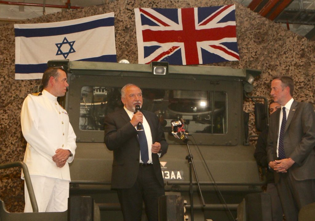 Avigdor Lieberman (centre) speaking underneath Israeli and British flags, with ambassador Quarrey on the right. 