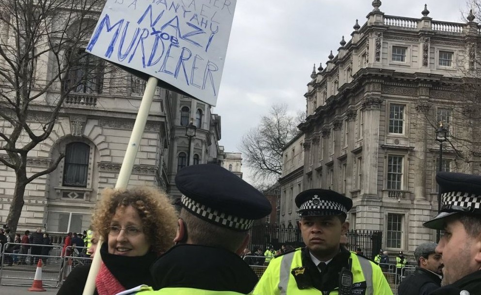 One demonstrator carries a banner branding Netanyahu a "Nazi murderer'. She told Jewish News' reporter to 'f*** off' after being asked for a comment, before offering an approving thumbs up to a group of Neturei Karta protesters as she joined the demo.