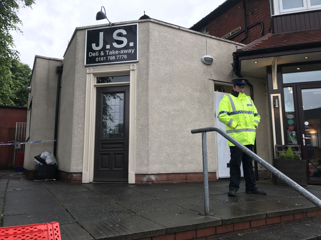 A policeman stands guard outside the JS restaurant, after the arson attack Photo credit: Steven Allen