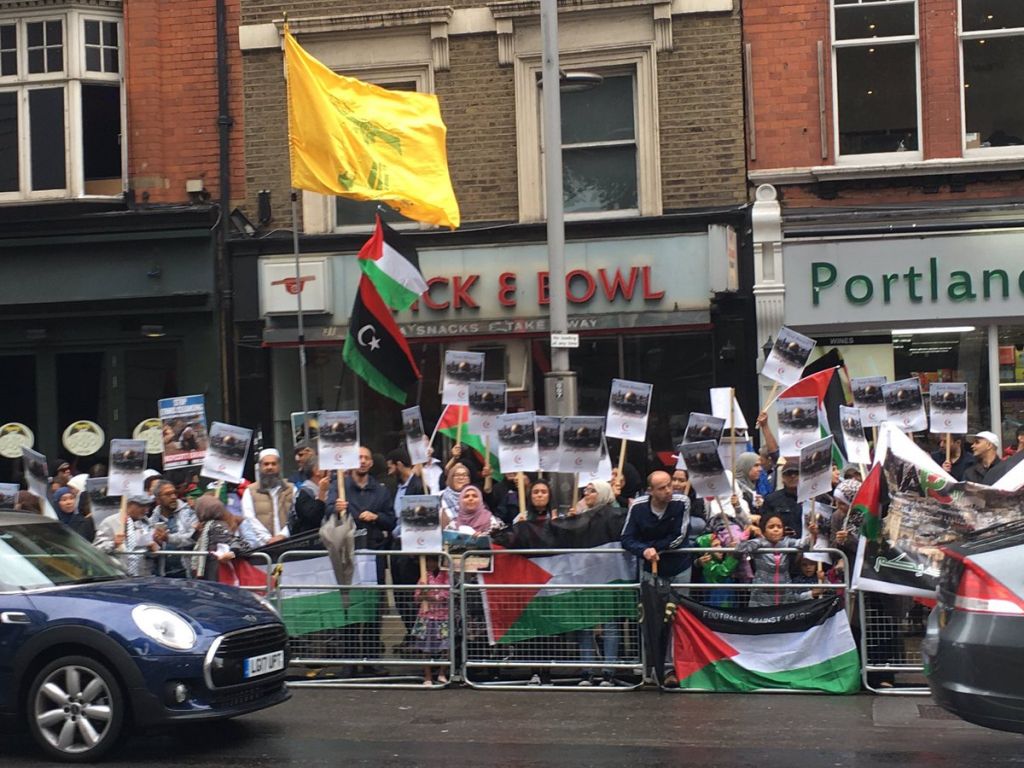 Hezbollah flag flying high at the protest. Credit: Conservative Friends of Israel on Twitter 