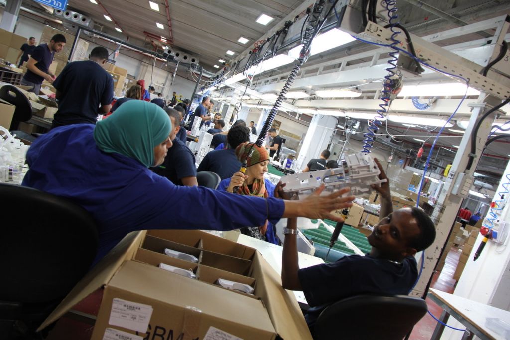 Israeli and Palestinian workers, working together at a Sodastream factory, whose headquarters are in the West Bank 