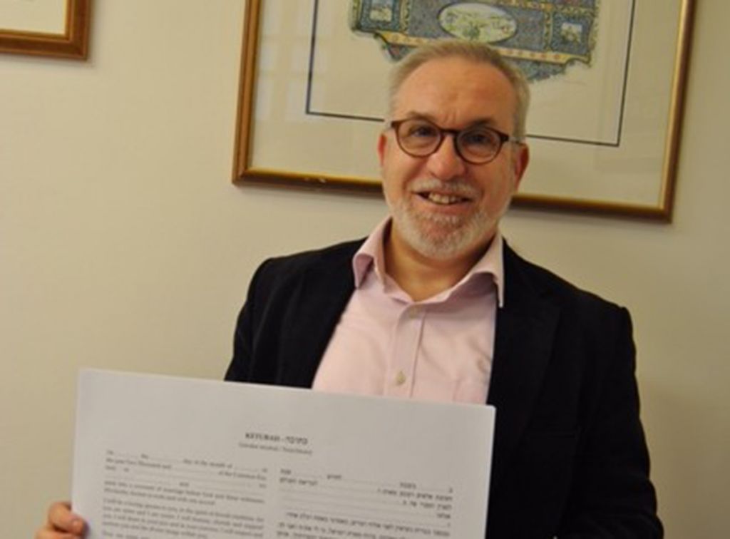 Rabbi Mark Solomon with new Ketubah text in front of classic Liberal Ketubah 