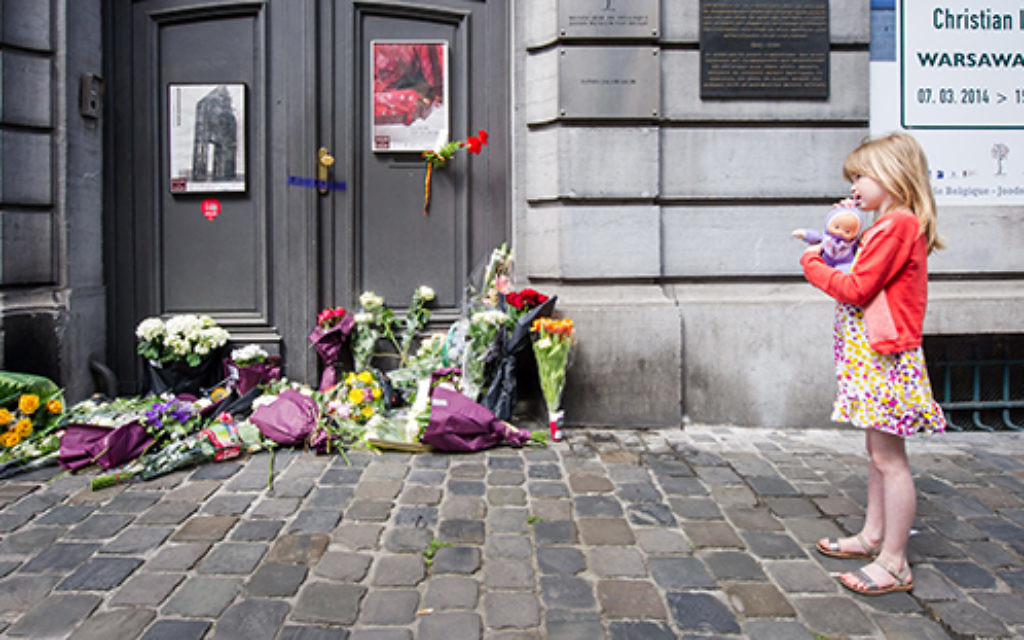 A girl stands next to flowers at the Jewish Museum in Brussels. Photo: AP
