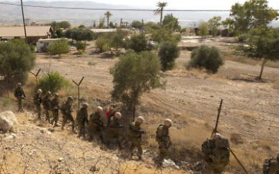Israeli soldiers patrol a fence in the West Bank.
