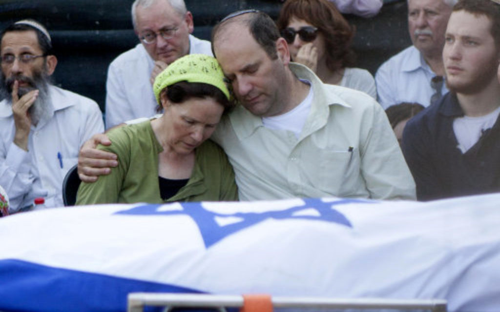 Avi and Rachel Fraenkel embrace during the funeral of their son, Naftali.