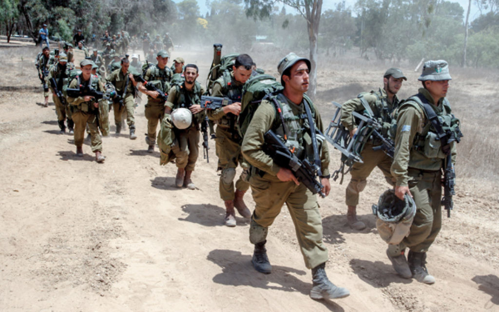 Israeli combat soldiers carry their gear as they walk towards a staging area before entering the Gaza strip. Photo: Jinipix/Israel Sun