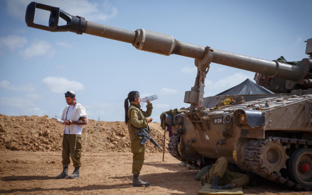 An Israeli soldier prays along the southern Israeli border.