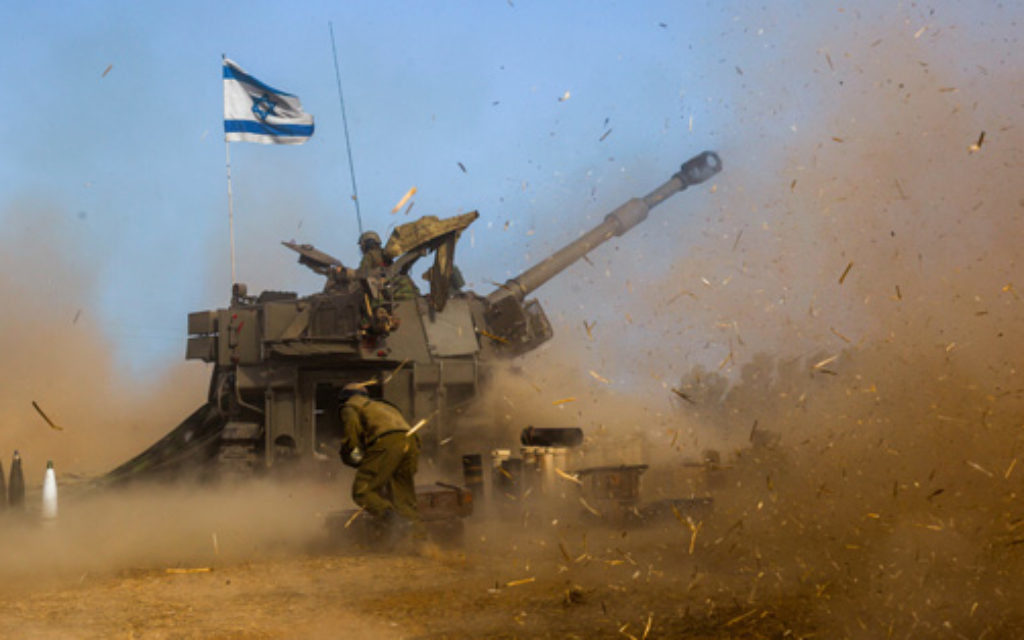 Israeli soldiers on a 155mm M109 Dores self-propelled howitzer fire a shell towards Gaza.