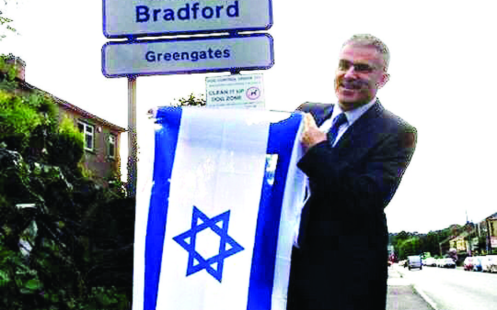 Ambassador Taub holding the Israeli flag on a visit to Bradford last week