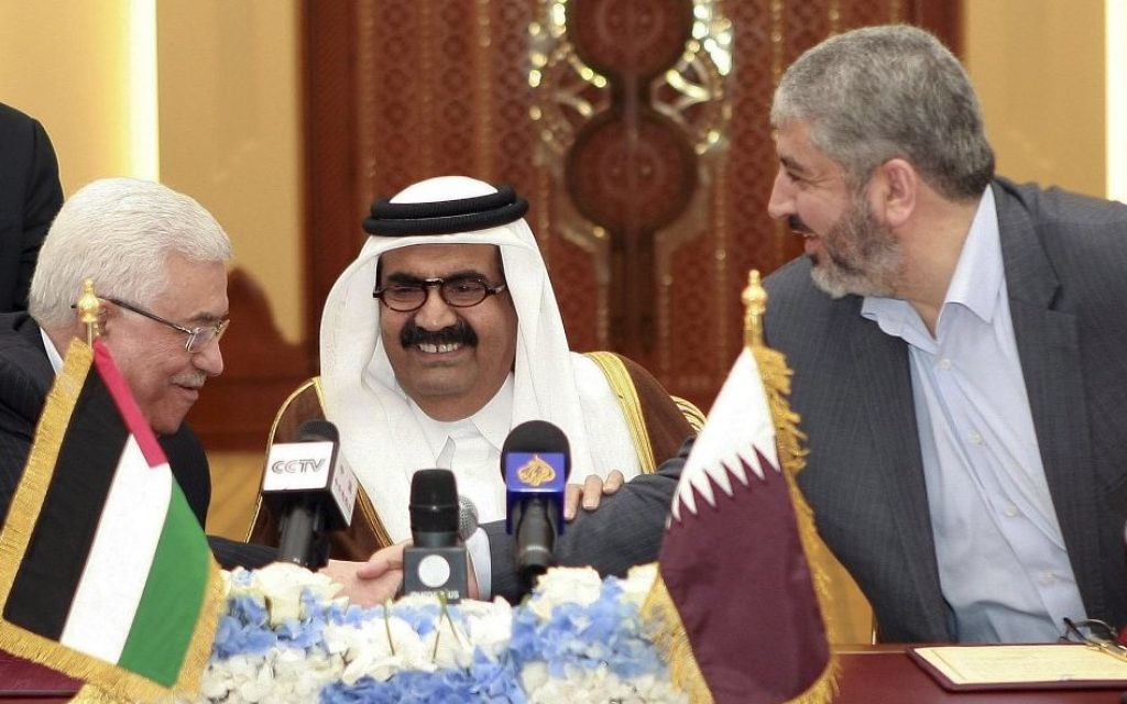 Palestinian President Mahmoud Abbas, left, shakes hands with Hamas leader Khaled Mashaal, right, between the Emir of Qatar.