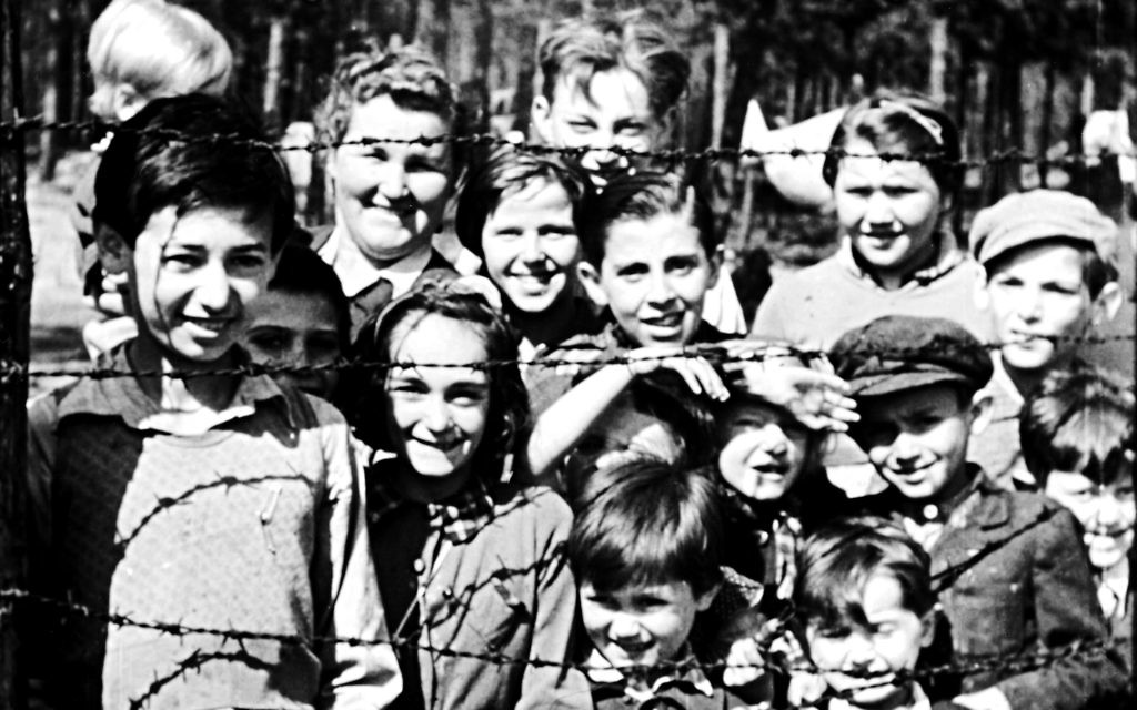 Night will fall pic (credit IWM) children smiling through barbed wire