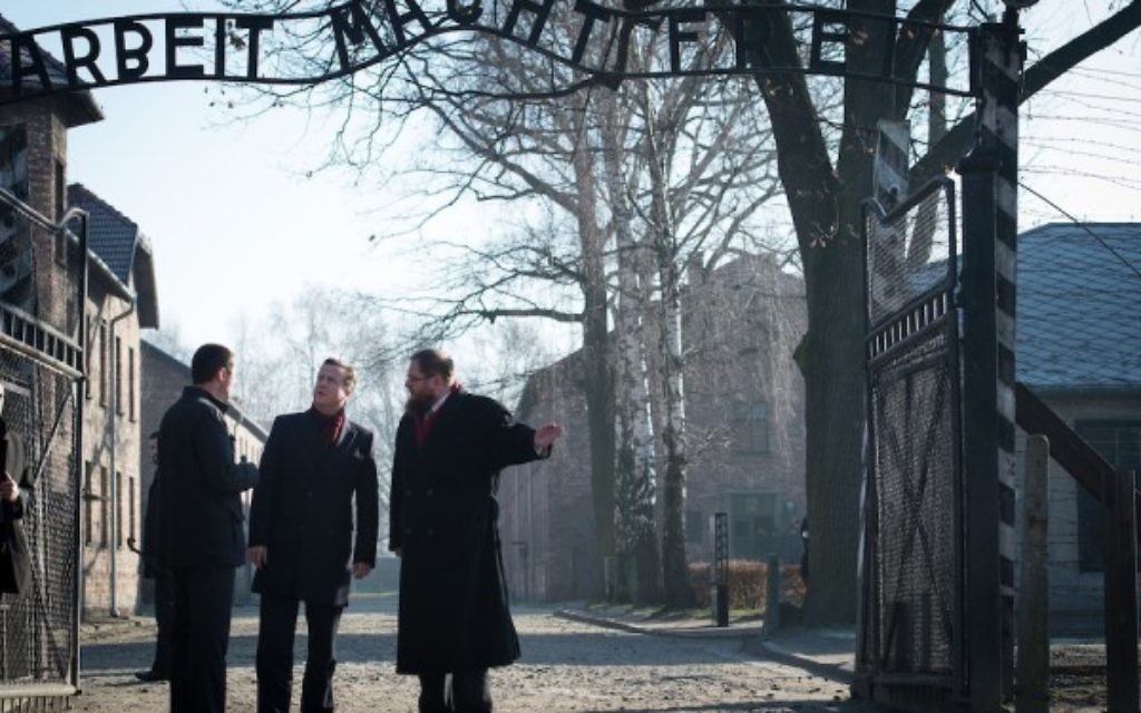 Prime Minister David Cameron stands under the entrance gates to Auschwitz, during a visit to the former Nazi death camp in Poland, where he has made his visit since becoming Prime Minister. PRESS ASSOCIATION Photo. Picture date: Wednesday December 10, 2014. The Prime Minister is travelling to the notorious site on the way back from Turkey, where he held talks with President Recep Tayyip Erdogan. See PA story POLITICS Cameron. Photo credit should read: Stefan Rousseau/PA Wire