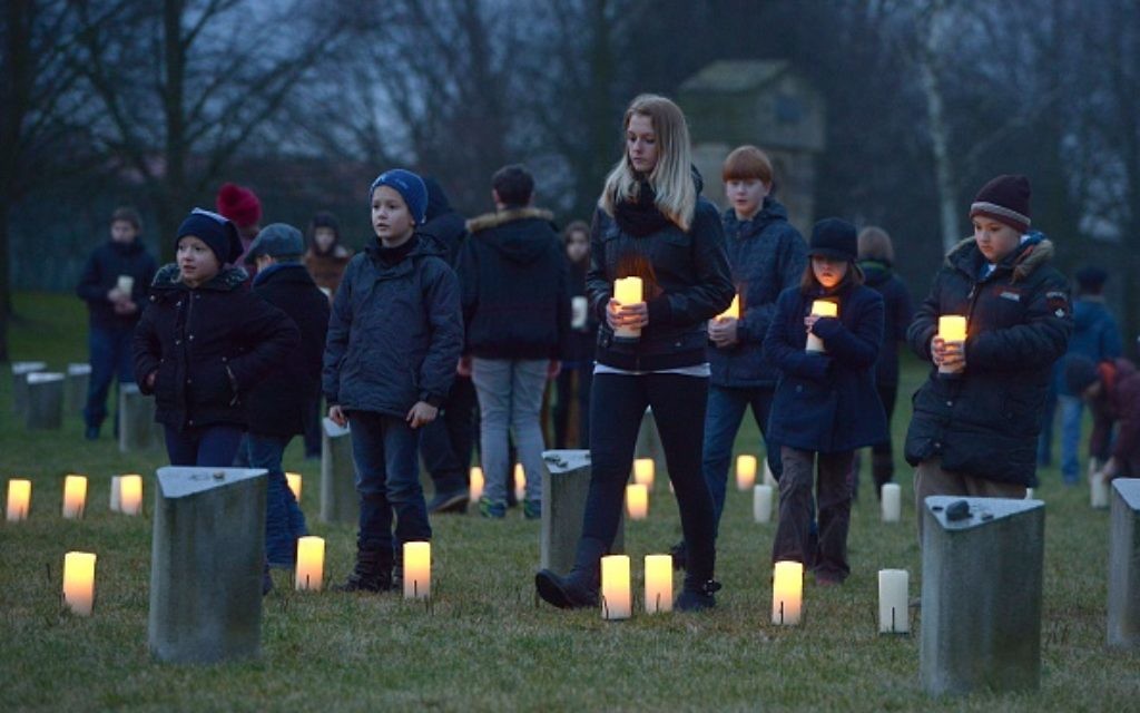 Children bring candles to at a Jewish cemetery at the former Terezin Nazi concentration camp on January 27, 2015, in Terezin (Theresiendstadt ) during the ceremony to mark the 70th anniversary of the liberation of the former Nazi concentration camp Auschwitz-Birkenau in Oswiecim, Poland. AFP PHOTO / MICHAL CIZEK        (Photo credit should read MICHAL CIZEK/AFP/Getty Images)