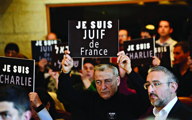 Members of the French Jewish community hold signs reading "I am Charlie" and "I am a Jew from France" at a rally in Jerusalem, Israel in January 2015