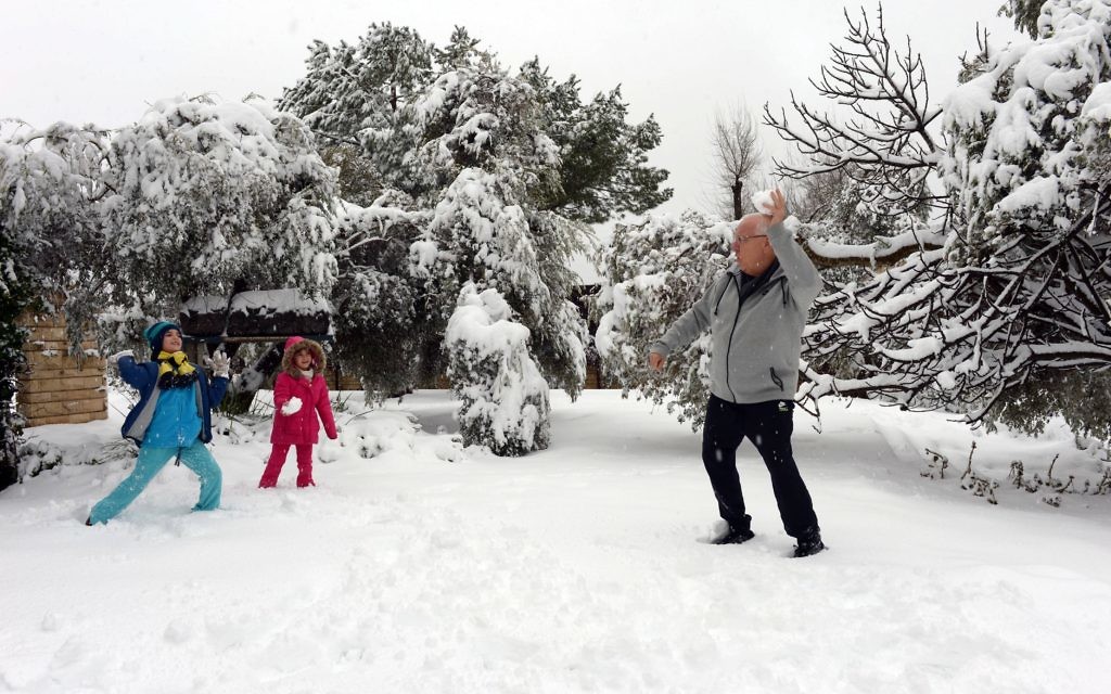 Israeli President Reuven Rivlin plays with granddaughters Karni and Ziv in the snow that covered his Jerusalem residence's garden.