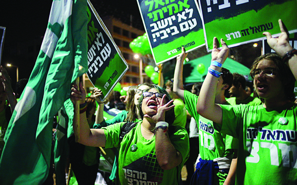 Protesters hold banners in Hebrew that read, "The real left does not sit with Bibi," during a rally against the government of Israeli Prime Minister Benjamin Netanyahu, in Tel Aviv, Saturday, March 7, 2015. Israel will hold legislative elections on March 17, 2015. (AP Photo/Ariel Schalit)