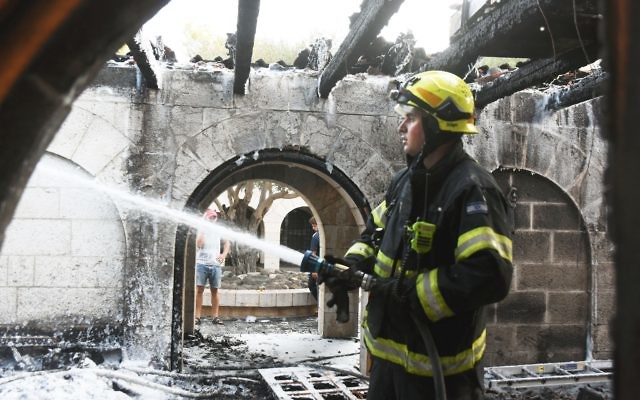A firefighter continues to put out the blaze after a fire heavily damages the Church of Loaves and Fishes on Sea of Galilee 

(Photo by Avihu Sahpira/Israel Sun)