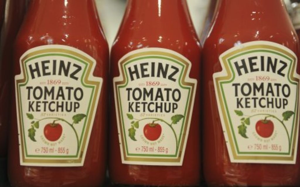 Bottles of Heinz ketchup on display in a supermarket.