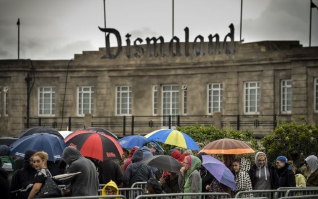 People queue in the rain to buy tickets for Banksy's exhibition theme park 'Dismaland' at Weston-super-Mare, Somerset.
