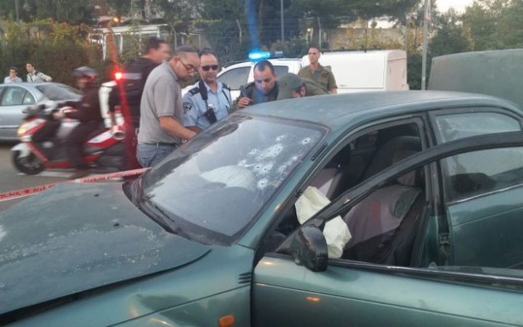 Bullet holes in a car are examined following the attack (Image via Israel News Flash on Twitter)