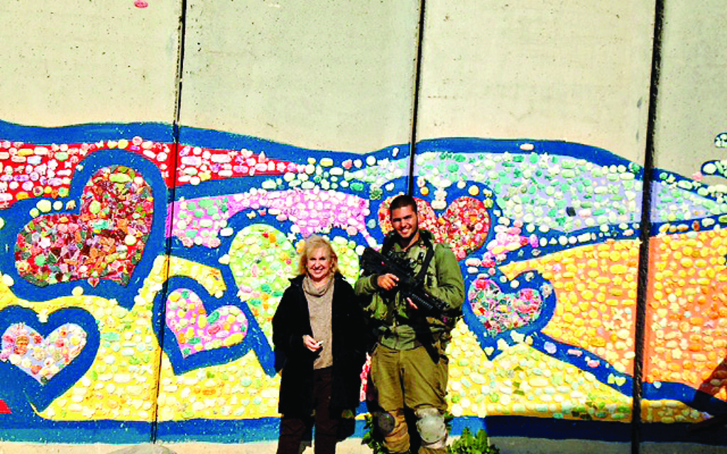Gillian with a soldier and part of Path to Peace mosaic