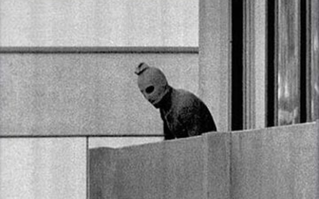 A masked member of Black September appears on a balcony during the terror attack