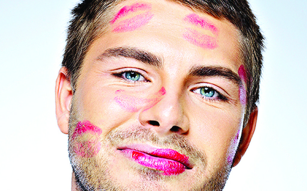 man with face full of lipstick marks of kisses