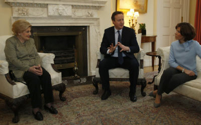 Britain's Prime Minister David Cameron, center, gestures as he talks to a group of Holocaust survivors, including Susie Lind, inside Downing Street to mark Holocaust Memorial Day, with TV presenter Natasha Kaplinsky, right, in London, Wednesday, Jan. 27, 2016. (AP Photo/Alastair Grant, Pool)