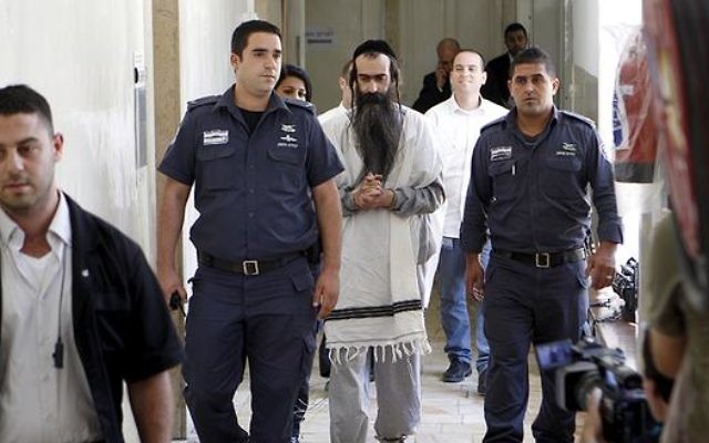 Yishai Schlissel being led away by police in handcuffs, following the murder of the 16-year old Shira Banki