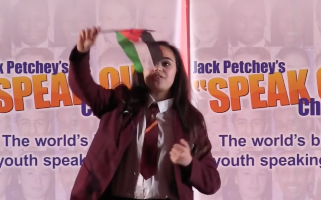 Leanne Mohamad waving a Palestinian flag at the end of her speech