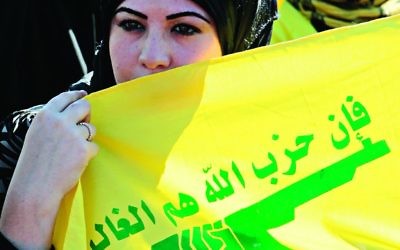 A woman holding a Hezbollah flag during an Al Quds Day march