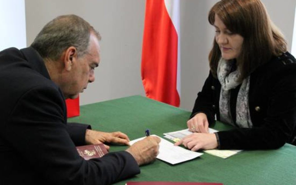 Avram Grant singing official documents to accept his passport (Picture credit: Konrad Jagodzinski / Polish Embassy UK)