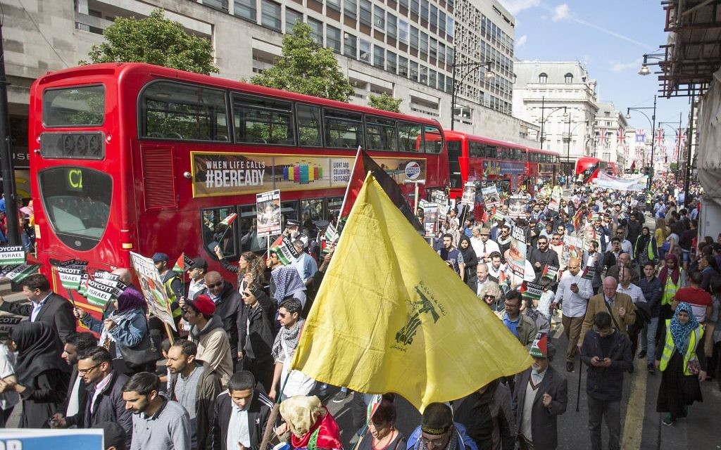 A Hezbollah supporter waves the terror flag in central London during Al Quds Day.