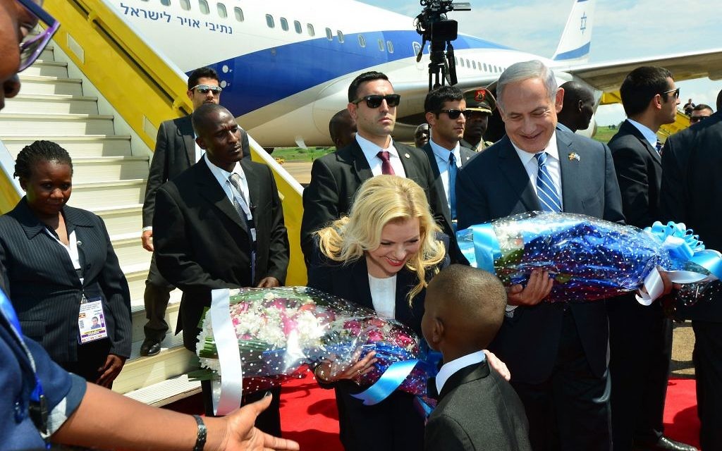 Sara Netanyahu receives flowers from local schoolchildren upon arriving in Uganda ( JINI Photo Agency, LTD) Sara Netanyahu receives flowers from local schoolchildren upon arriving in Uganda ( JINI Photo Agency, LTD)