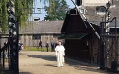 Pope Francis entering Auschwitz I camp through 'Arbeit macht frei' gate.