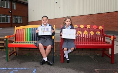 Year 5 pupil Melissa Charles and Liat Tilsiter from Year 2, on the benches which they designed (Photo by James Shaw)