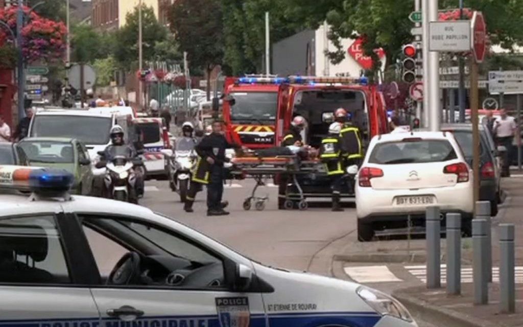 Emergency services transport a person into a waiting ambulance, after two attackers seized hostages in a church near the Normandy city of Rouen on Tuesday  (Photo credit: BFM via AP)