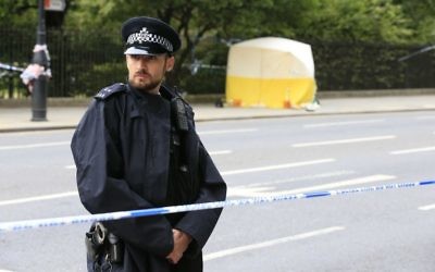 A police officer stands guard near a tent in Russell Square, after a knife attack in which a woman in her 60s was killed and five people were injured. A 19-year-old man has been arrested  (Photo credit: Jonathan Brady/PA Wire.)