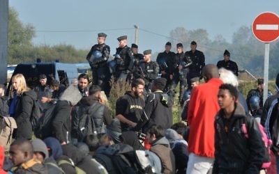 Police create a cordon as several large fires broke out in the near deserted migrant camp in Calais, northern France on the third day of the operation to clear the Jungle. (Photo credit: John Stillwell/PA Wire)
