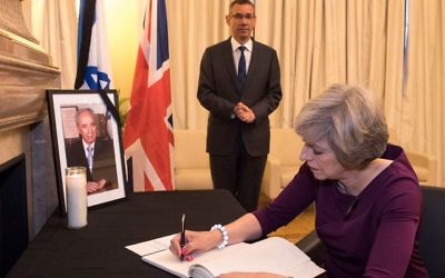 Theresa May signing the book of condolences at the Israeli Embassy in London