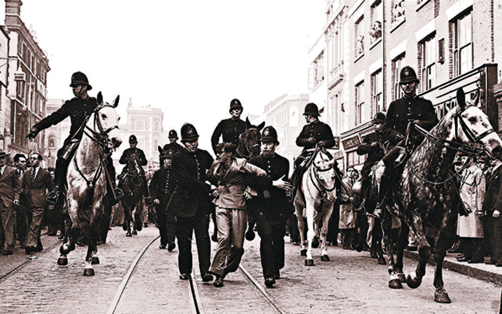 A demonstrator is taken away under arrest by police officers after a mounted baton charge, in East London, on Oct. 4, 1936, to stop fighting between anti-fascists and Sir Oswald Mosley's blackshirts.