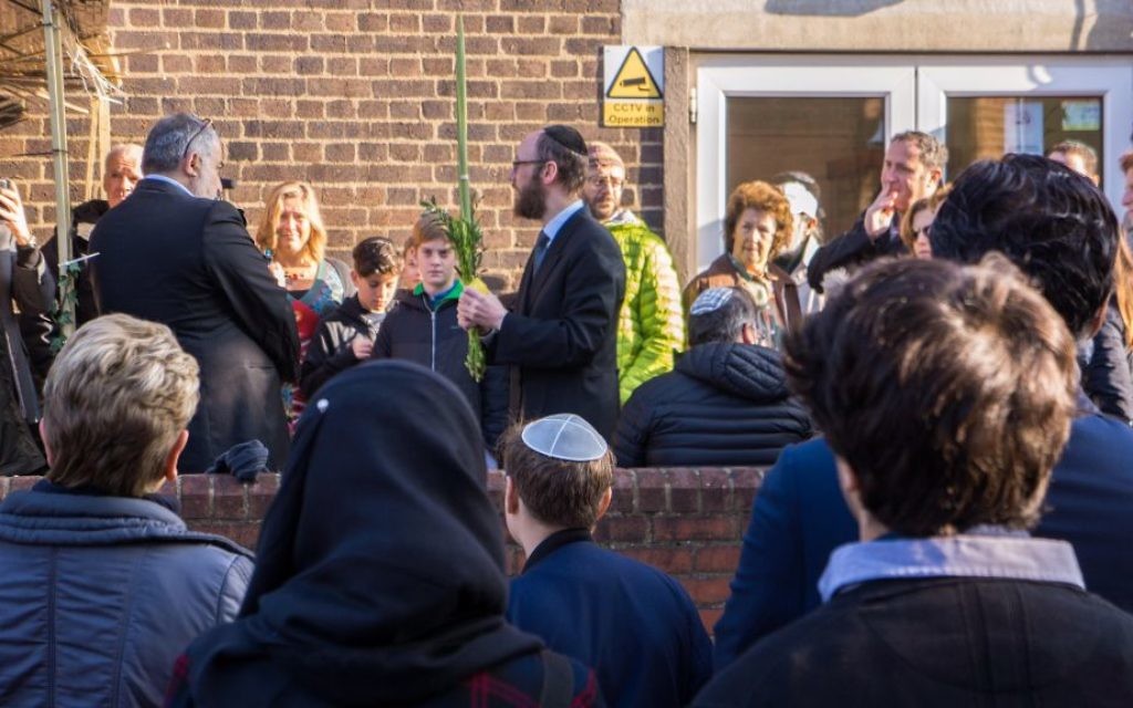 Rabbi Baruch Levine outside the mosque waving the lulav and etrog