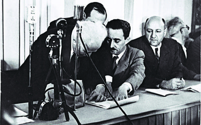 David Ben Gurion (left) signing the Declaration of Independence held by Moshe Sharet, with Eliezer