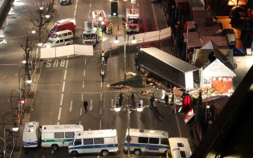 Police search the surroundings of a truck which run into a crowded Christmas market the evening before and killed several people in Berlin (Credit: Michael Kappeler/dpa via AP)