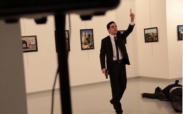 A man identified as Mevlut Mert Altintas stands over Andrei Karlov, the Russian Ambassador to Turkey, after shooting him at a photo gallery in Ankara, Turkey(AP Photo/Burhan Ozbilici)