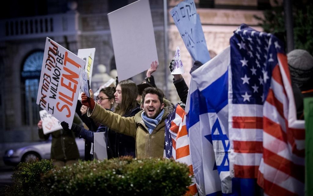 Protesters holding placards during near the Prime minister residence in Jerusalem against Trump’s recent anti-refugee and anti-migrant Executive Orders (Photo by: JINIPIX)