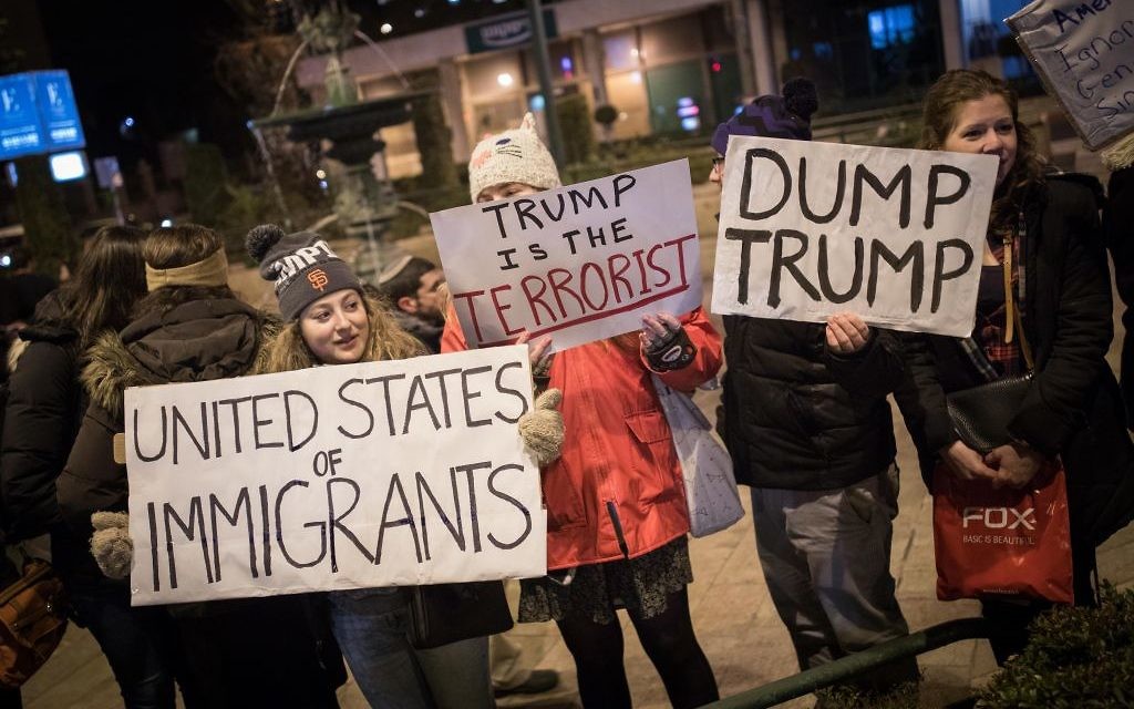 Protesters holding placards during near the Prime minister residence in Jerusalem against Trump’s recent anti-refugee and anti-migrant Executive Orders (Photo by: JINIPIX)