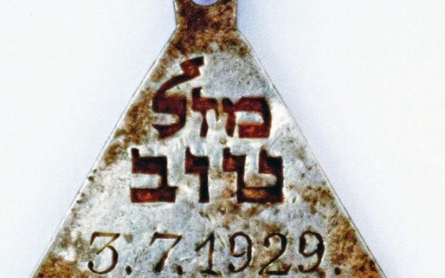 A pendant with the Hebrew words "Mazal Tov" and the date July 3, 1929, found at the site of the Nazi-operated Sobibor death camp.