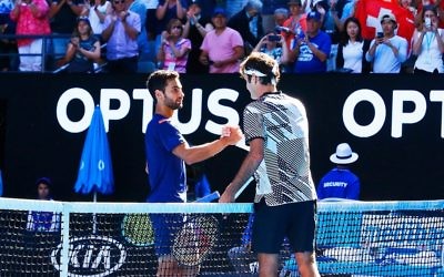 Noah Rubin congratulates Roger Federer after their second round clash on Wednesday morning. Picture: Peter Haskin/AJN
